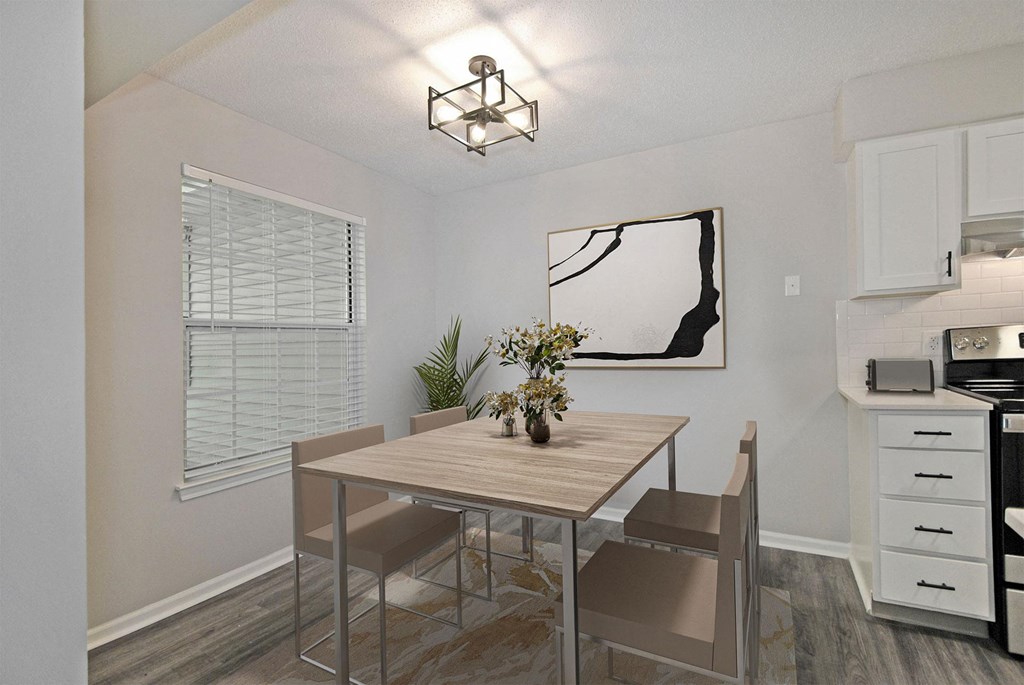 A dining room with a table and chairs.