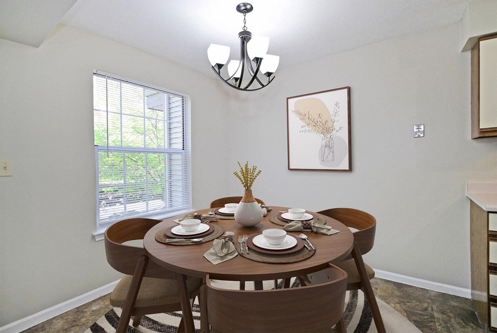 A dining room with a round table set for four.
