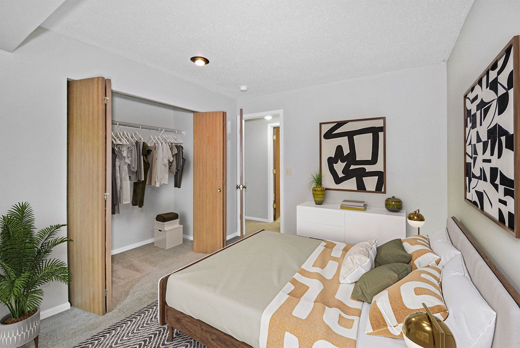 A bedroom with a bed, a wardrobe, and a plant.