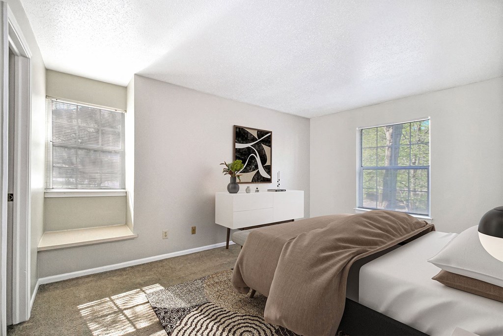 A bedroom with a bed, nightstand, and window.