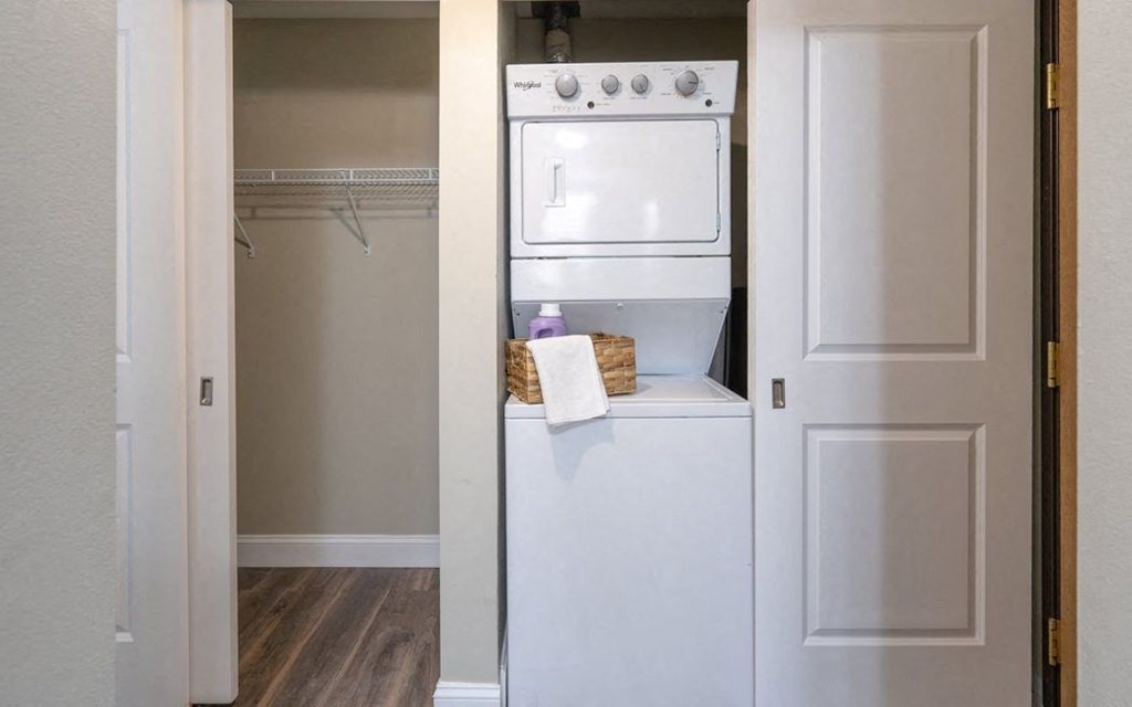 a white washer and dryer in a room with a closet