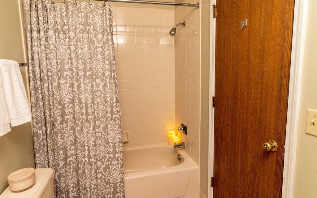 a bathroom with a white tub and a shower curtain