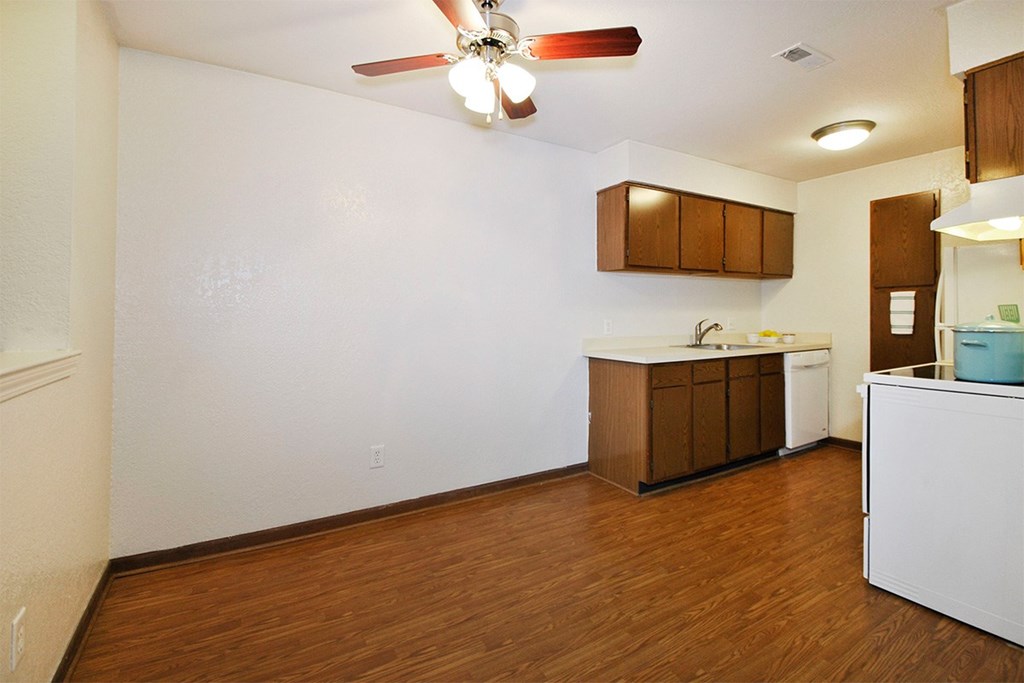 A kitchen with brown cabinets and a white counter.
