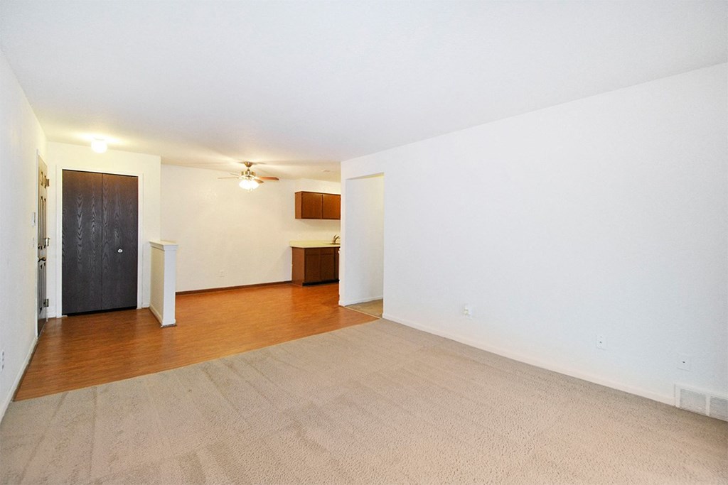 A room with a carpeted floor and a door on the left side.