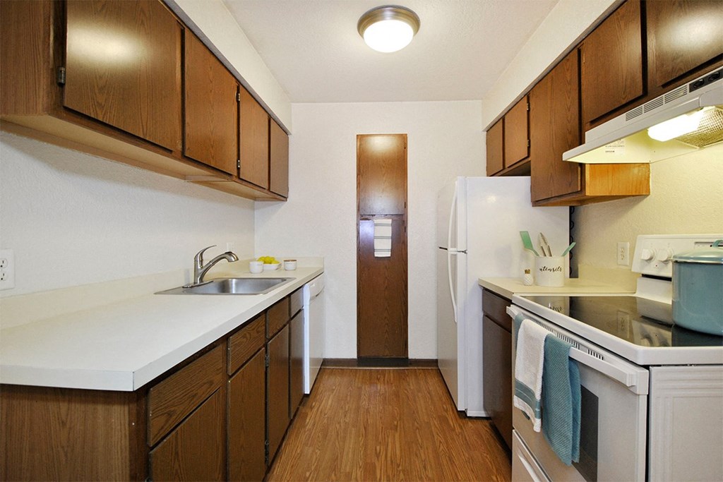 A kitchen with brown cabinets and a white fridge.