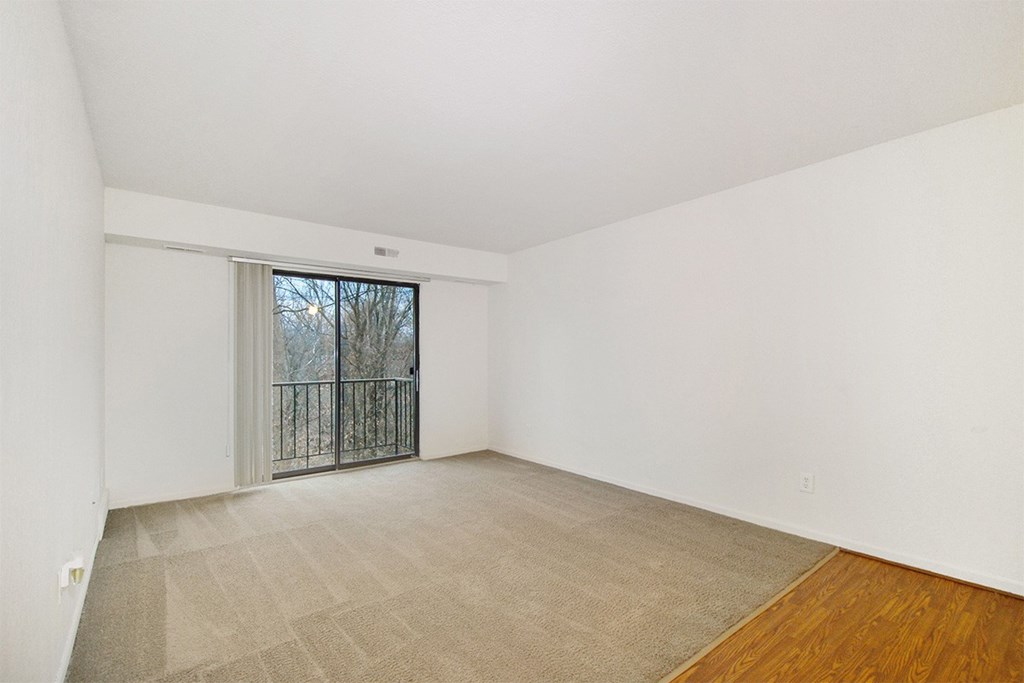 A room with a sliding glass door leading to a balcony.