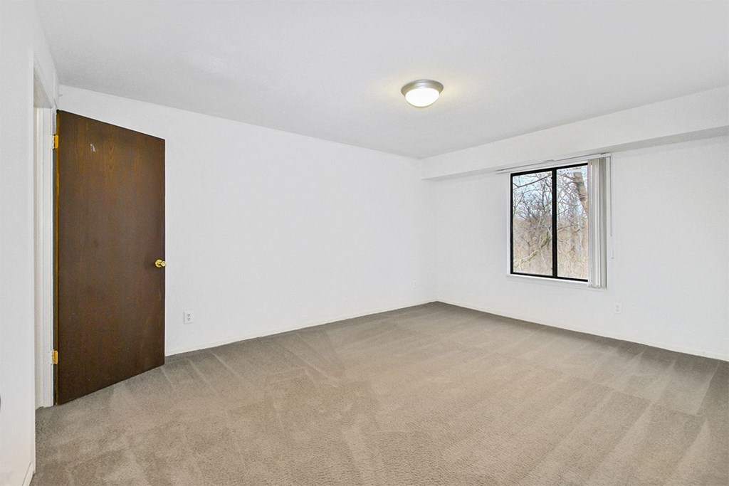 A room with a carpeted floor and a picture frame on the wall.