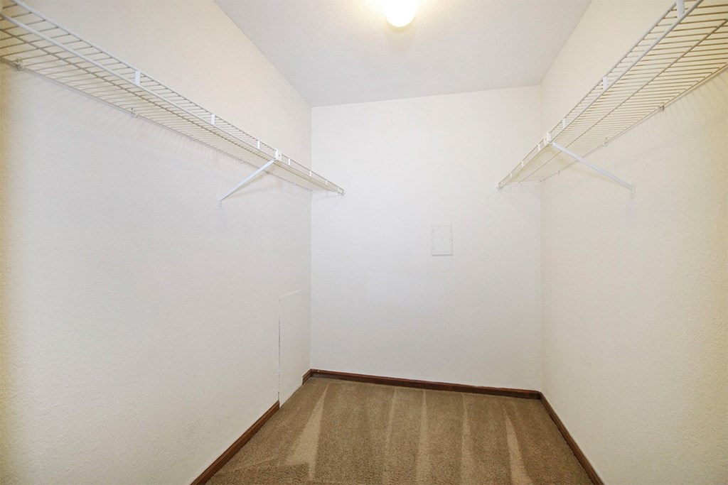 Empty room with white walls and brown carpet.