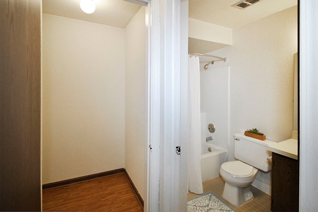 A white bathroom with a toilet, sink, and shower.
