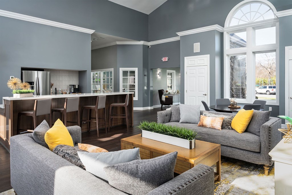 a living room with couches and a coffee table and a kitchen