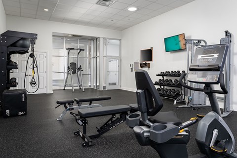 a gym with exercise equipment and a tv