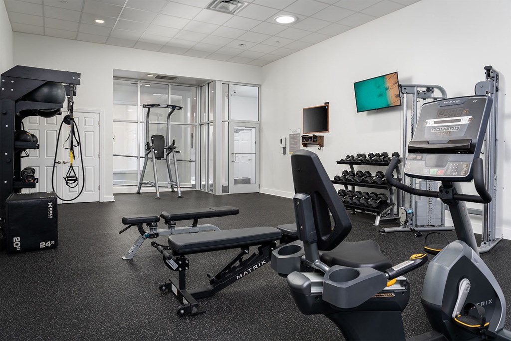 a gym with exercise equipment and a tv