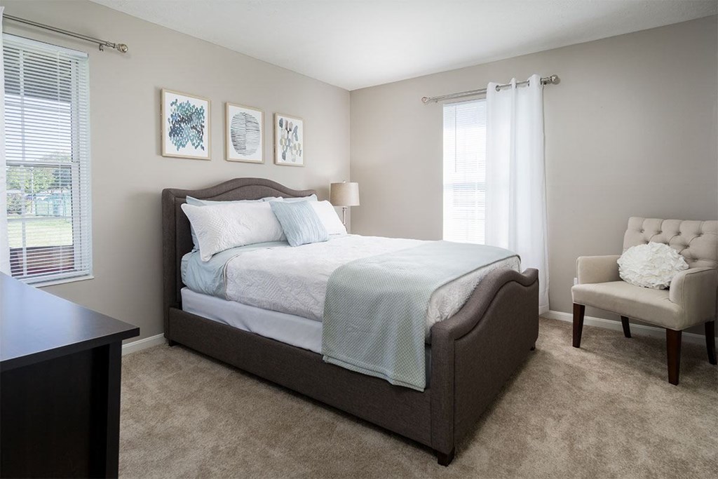 a bedroom with a bed and a chair