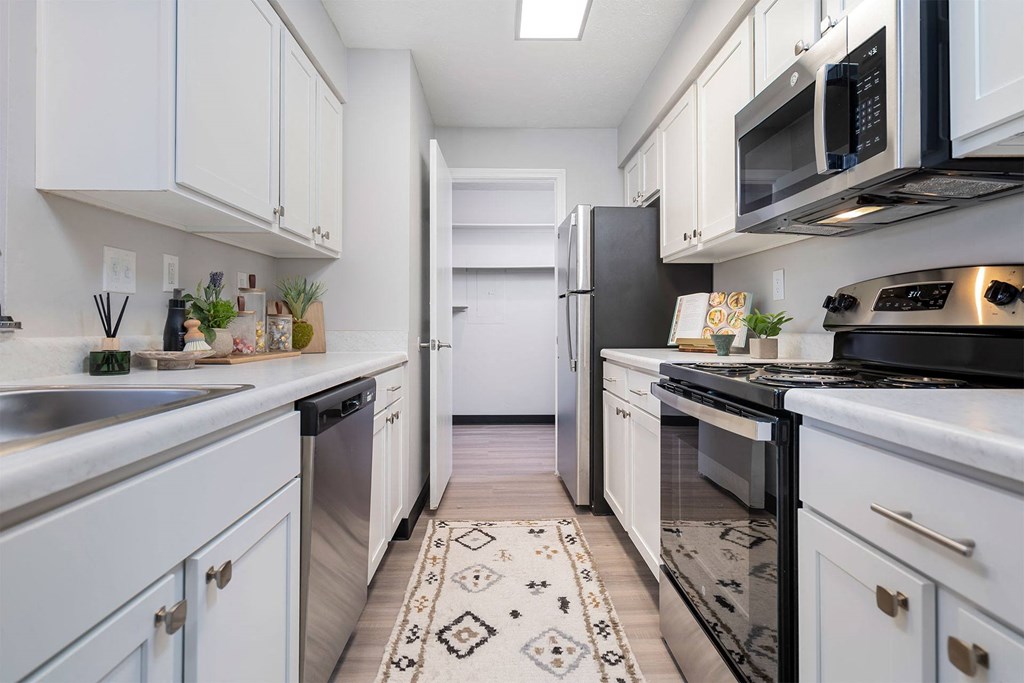 a kitchen with white cabinets and black appliances