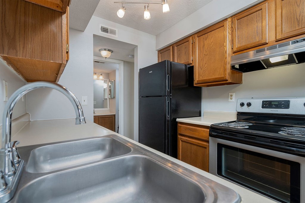 a kitchen with a sink and a black refrigerator