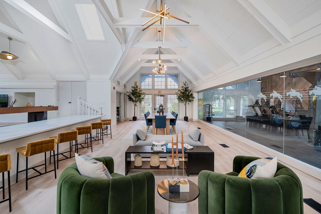 a living room with green couches and chairs and a table with candles