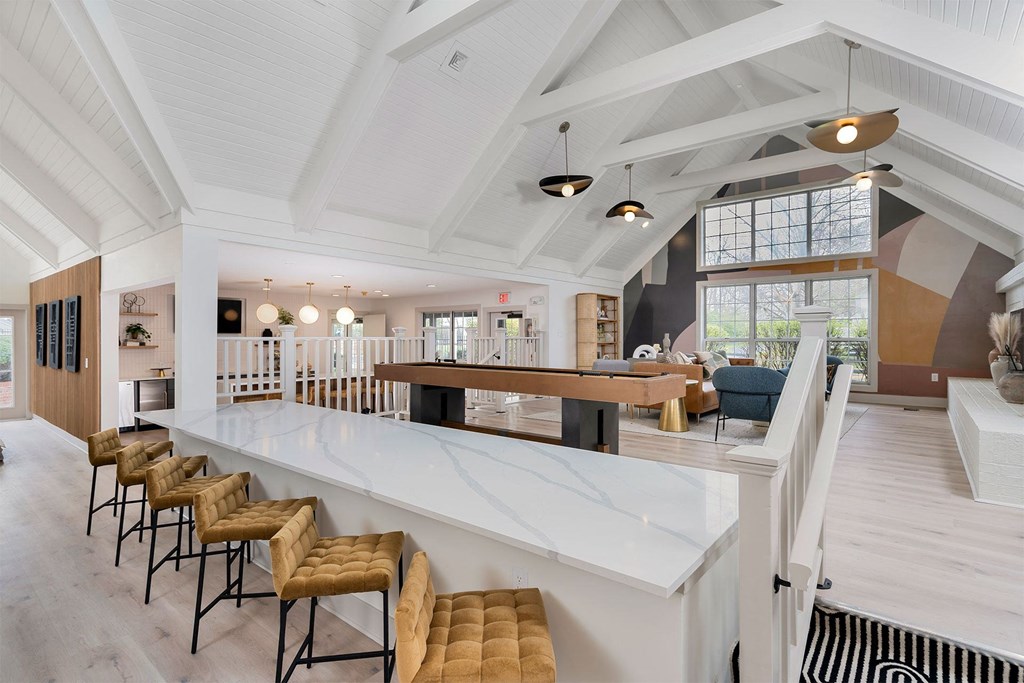 a kitchen with a long counter top and a bar with chairs