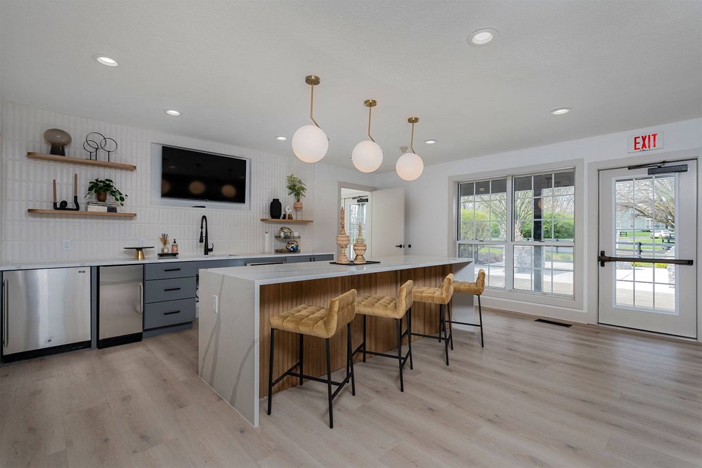 a large kitchen with an island and chairs in front of a door