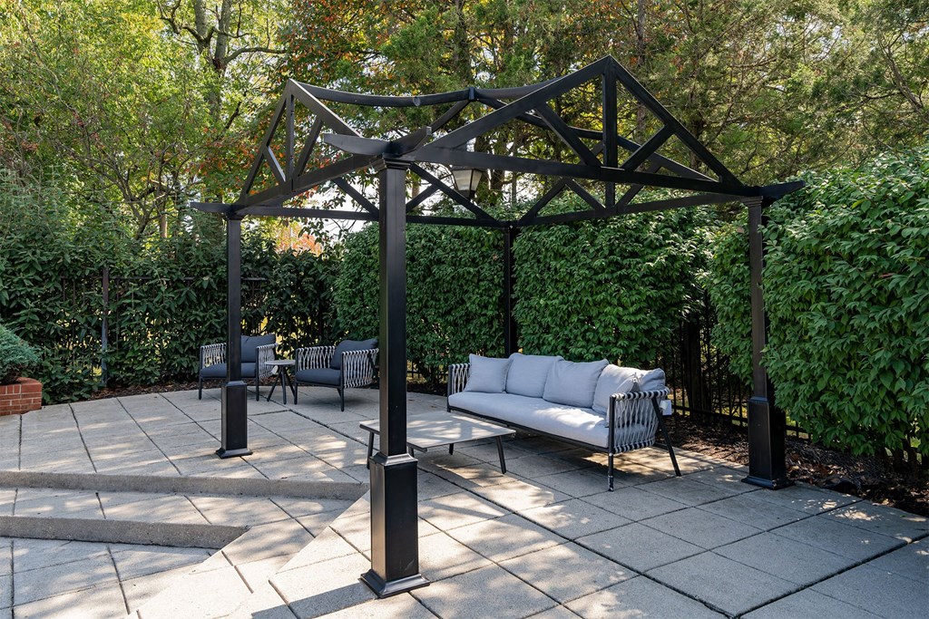 a patio with a bench and a gazebo