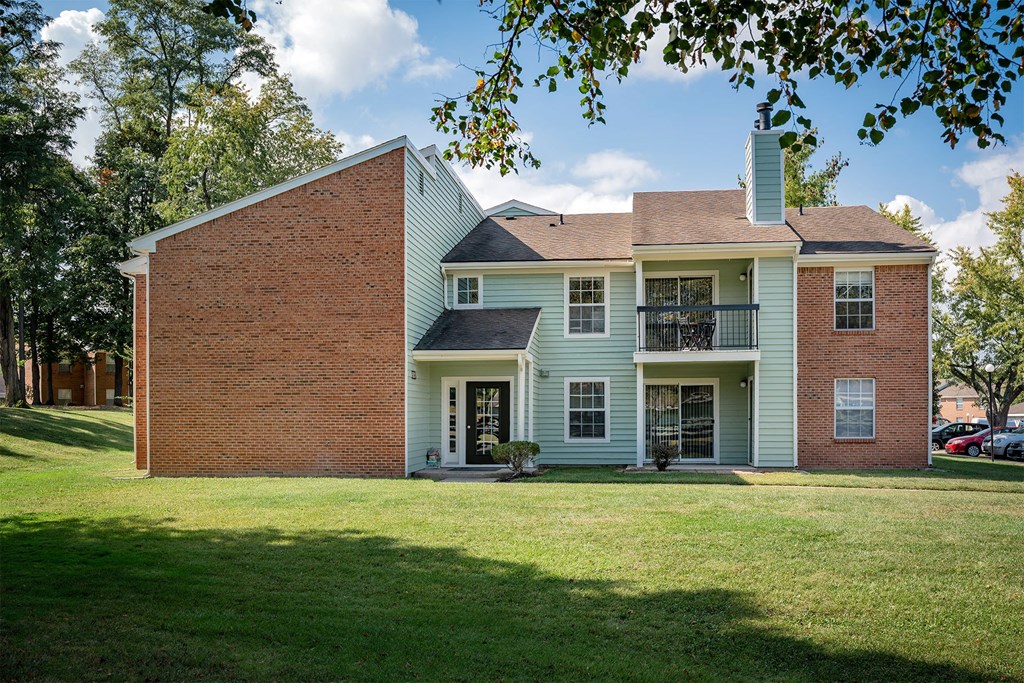 a large white house with a brick facade and a lawn