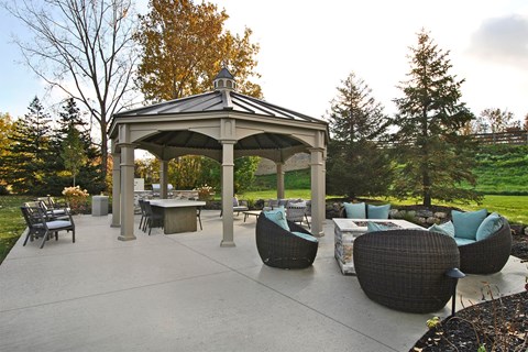 a patio with a gazebo and tables and chairs