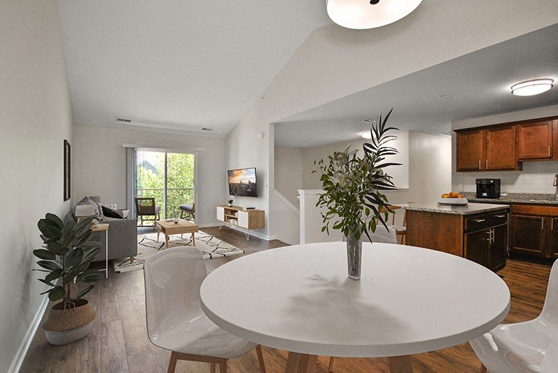 a living room and dining room with a white table and a plant
