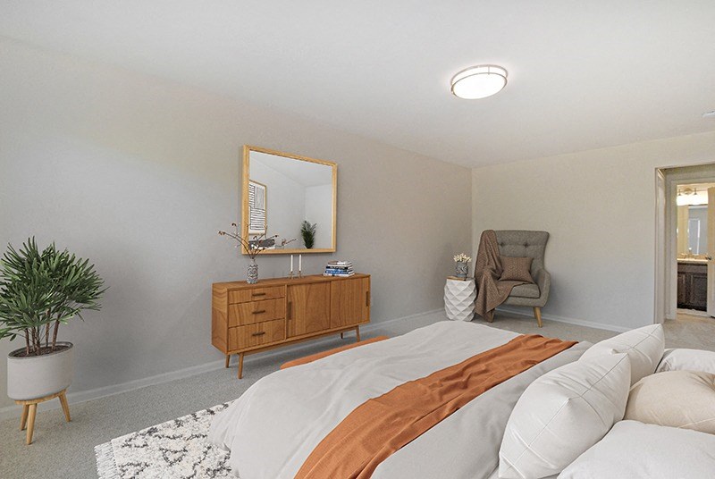 a bedroom with a bed and a dresser with a mirror