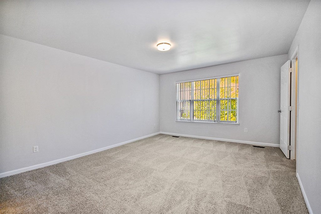 the living room of an empty home with a window