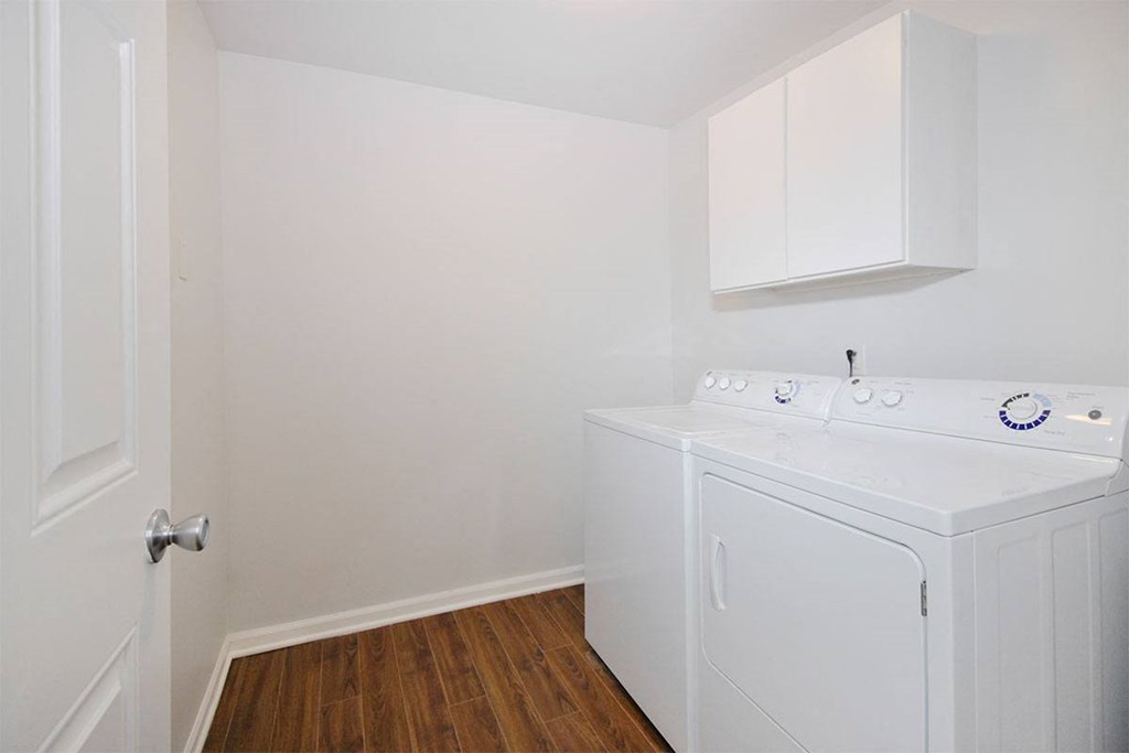 a white washer and dryer in a room with a wood floor