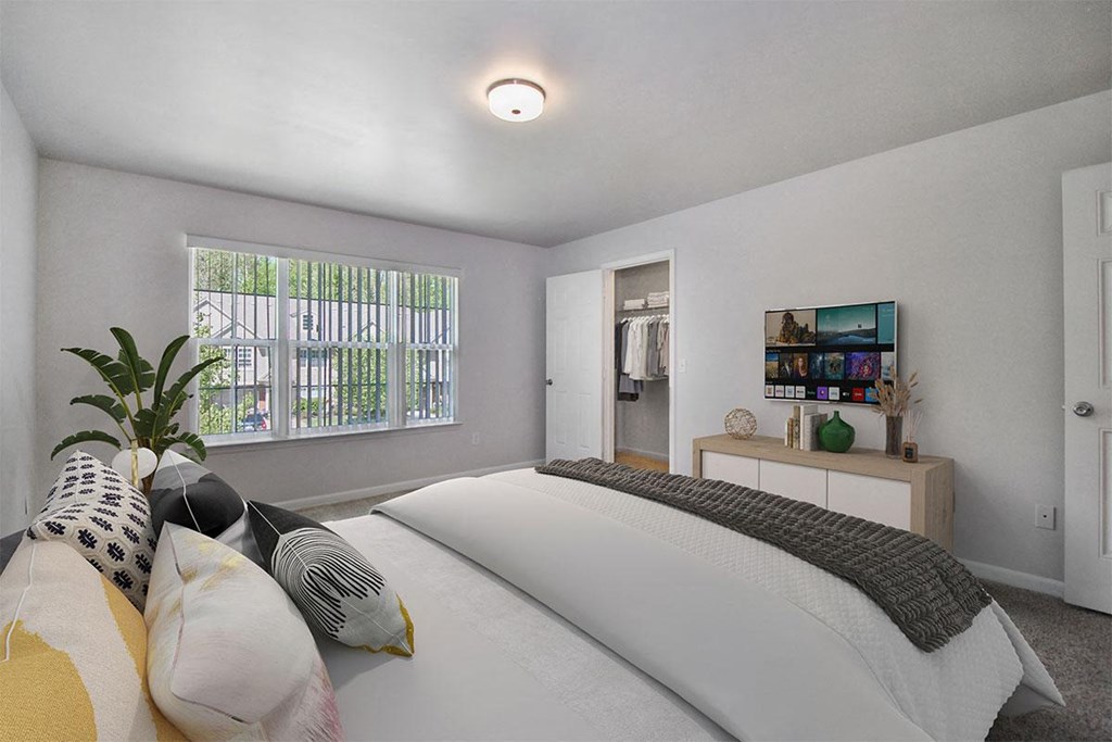 a white bedroom with a bed and a window