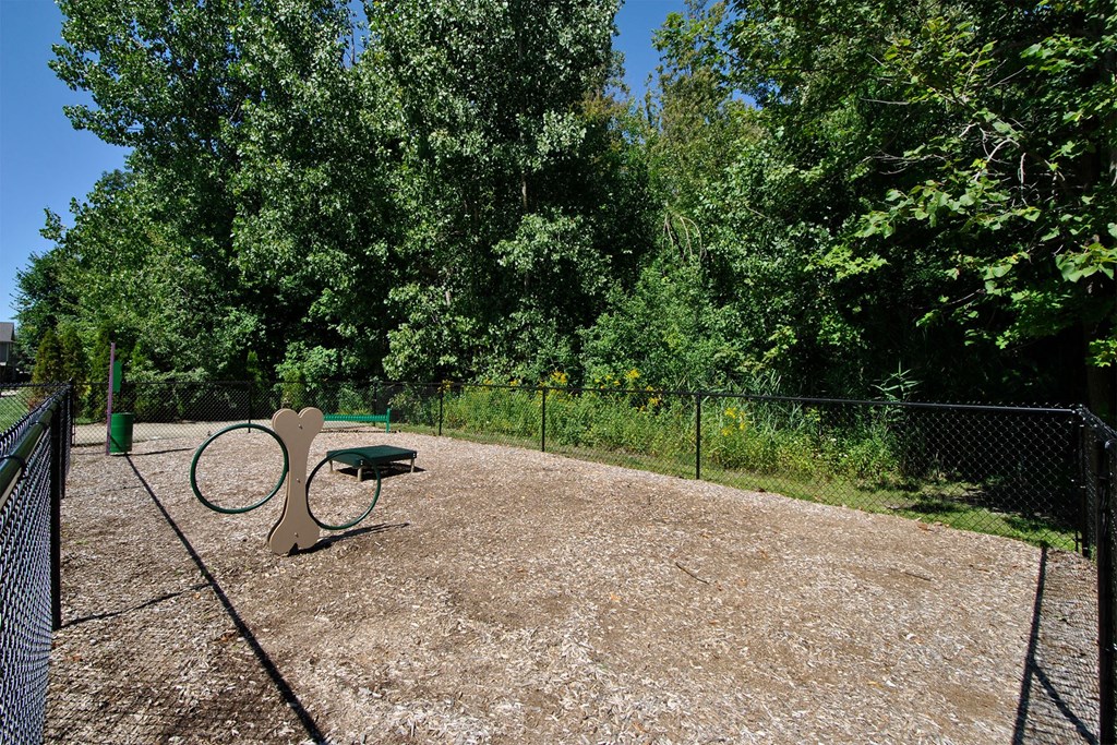 a tennis court in a park with a bench