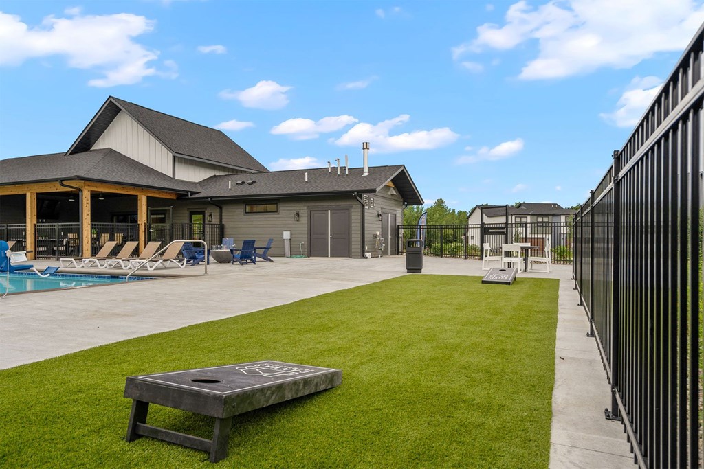 the backyard of a house with a pool and a fire pit