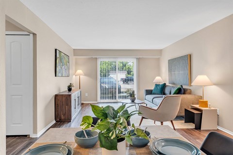 A living room with a couch, chair, and table with a plant on it.