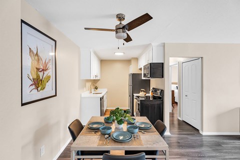 A dining room with a table set for a meal.