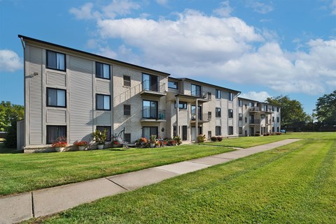 A row of modern apartment buildings with green lawns in front.