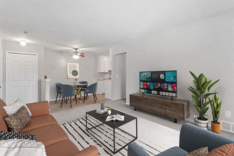 A living room with a brown couch, a coffee table, and a flat screen TV.