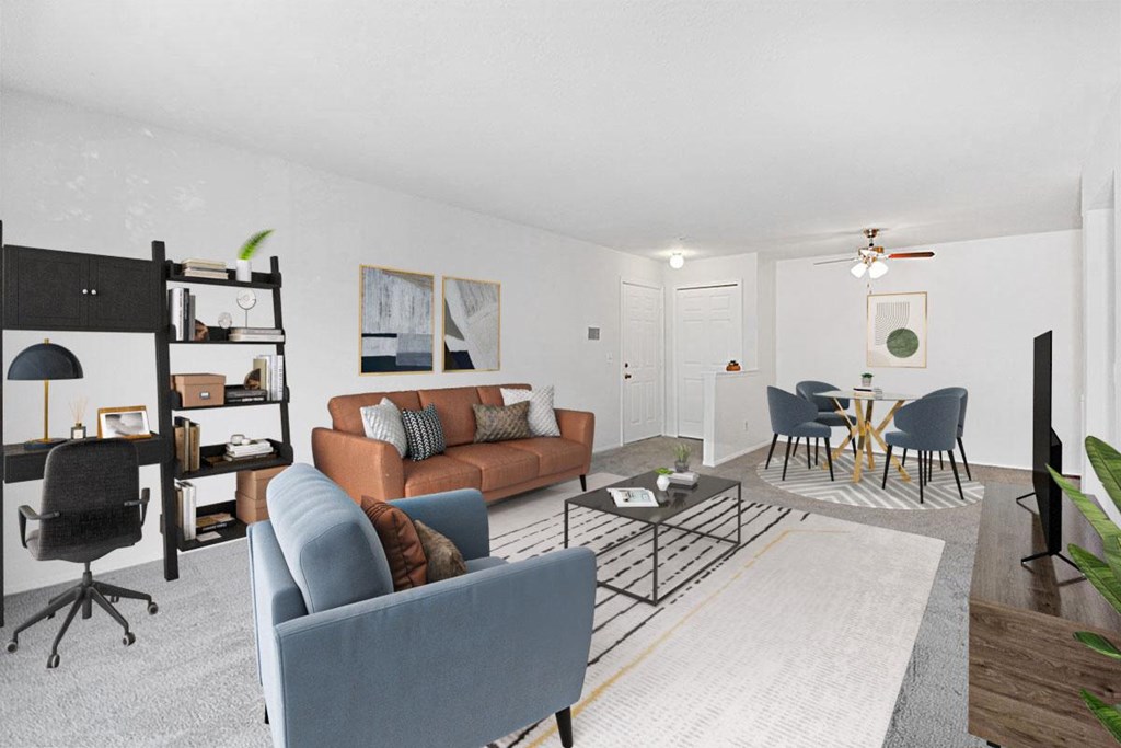 A living room with a blue couch and a grey rug.