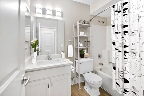 A white bathroom with a patterned shower curtain.