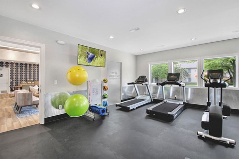A gym with treadmills, exercise balls, and other equipment.
