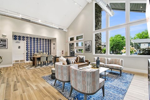 A living room with a striped couch and a blue rug.