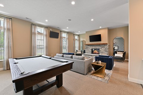 A large room with a pool table and a fireplace.
