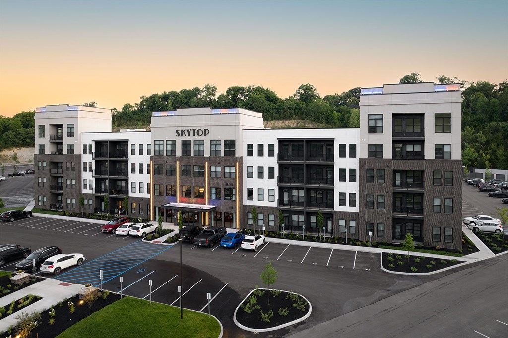 an aerial view of an apartment complex with cars in a parking lot