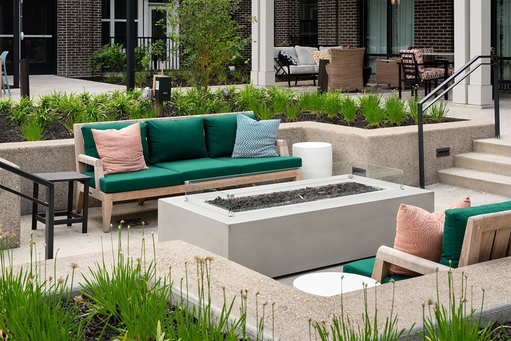 a patio with couches and chairs and a fire pit