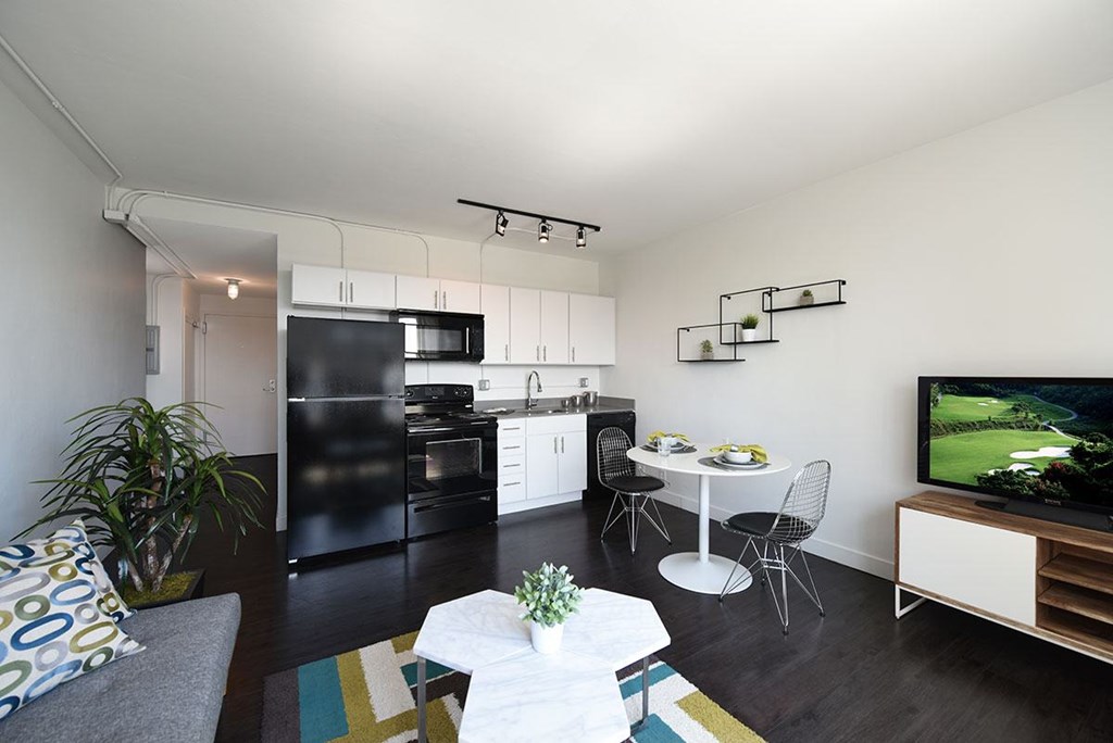 A modern kitchen with black appliances and white cabinets.