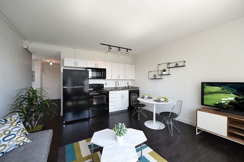 A modern kitchen with black appliances and white cabinets.