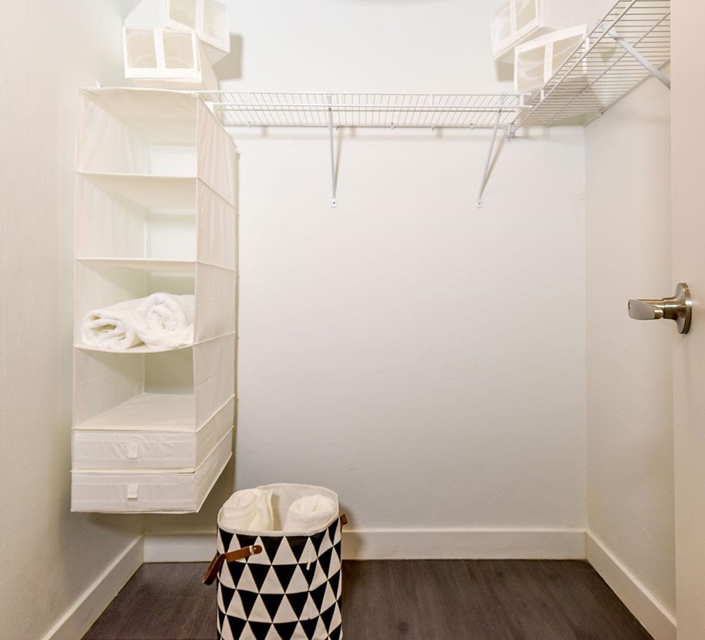 A white bathroom with a black and white checkered trash can.