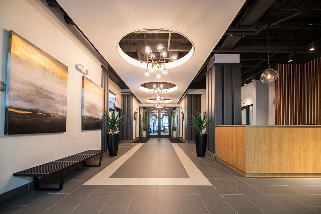 A hallway with a wooden bench and a reception desk.