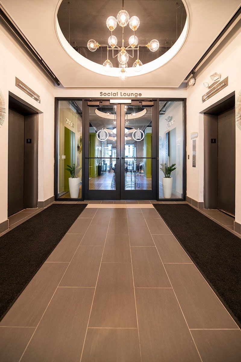 The Social Lounge has a brown floor and a chandelier hanging from the ceiling.