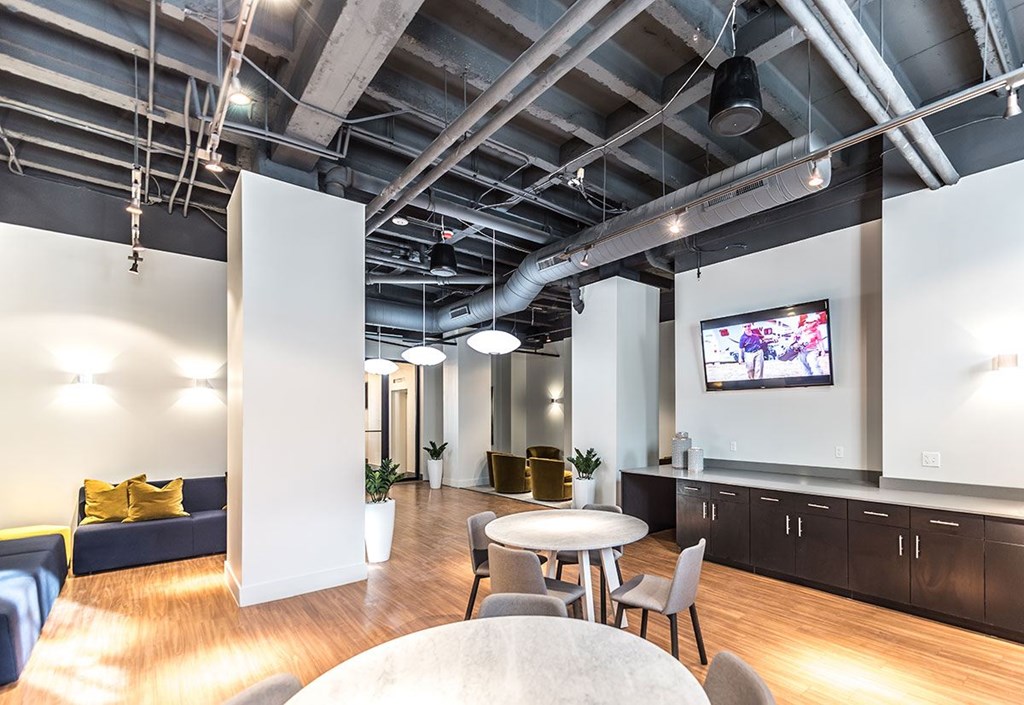 A modern living room with a television and a dining table.