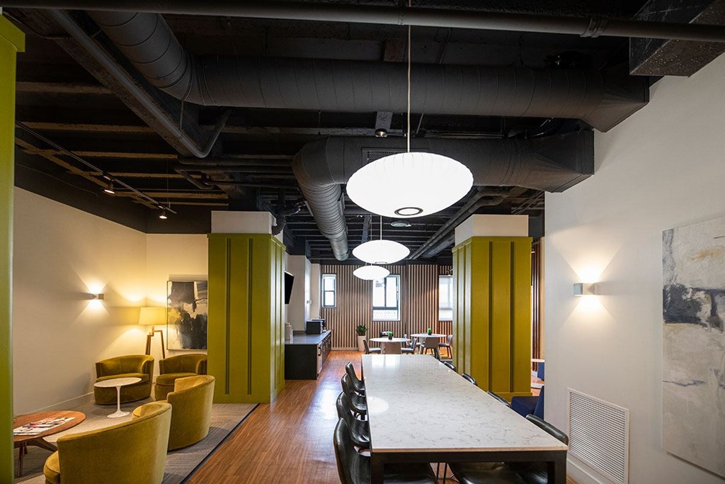 A long table is in the middle of a room with yellow chairs.